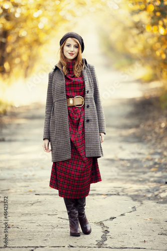 Photo: Style redhead girl at beautiful autumn alley. Style redhead girl at beautiful autumn alley.
