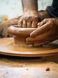 Potter hands making in clay on pottery wheel