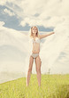 Young blond woman in white dress on background of the sky