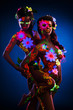 Photo: Couple women with glow uv body art and flowers Couple women with glow uv body art and flowers