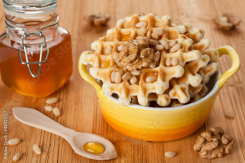 Photo: Sweet Belgian waffles with honey and nuts for a tasty breakfast Sweet Belgian waffles with honey and nuts for a tasty breakfast