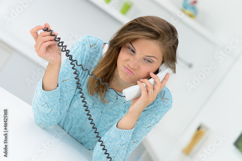 Photo: frustrierte junge frau am telefon frustrierte junge frau am telefon