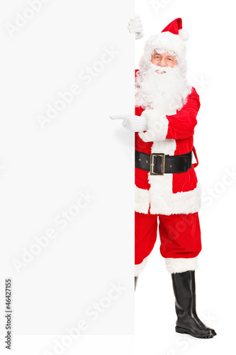 Photo: Santa claus posing next to a billboard and pointing Santa claus posing next to a billboard and pointing