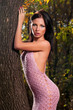 Photo: woman standing near a tree woman standing near a tree