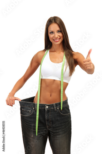 Photo: beautiful young woman with big jeans and measuring tape, beautiful young woman with big jeans and measuring tape,