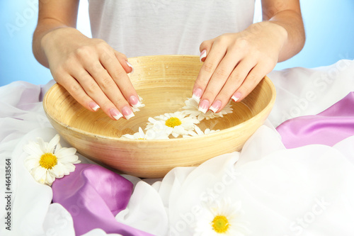 Photo: woman hands with wooden bowl of water with flowers, woman hands with wooden bowl of water with flowers,