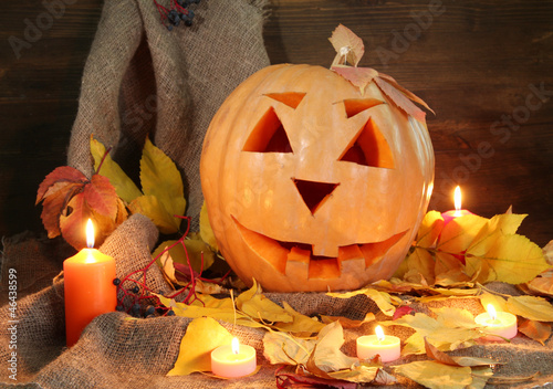 Photo: halloween pumpkin and autumn leaves, on wooden background halloween pumpkin and autumn leaves, on wooden background