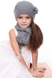 little girl in a knitted hat and gray scarf