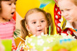 kids celebrating birthday party and blowing candles on cake