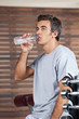 Man Drinking Water From Bottle At Health Club