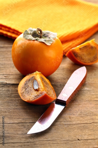 Photo: Persimmon fruit on a wooden table Persimmon fruit on a wooden table
