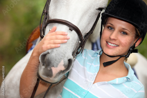 Photo: Young woman caressing her horse Young woman caressing her horse