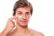 Handsome man with naked torso appliescream on his face