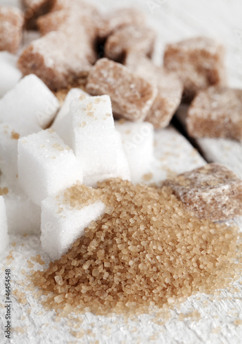 Photo: Little heap of white and brown sugar cubes on a wooden surface Little heap of white and brown sugar cubes on a wooden surface
