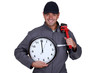 Handyman holding a pipe wrench and a clock