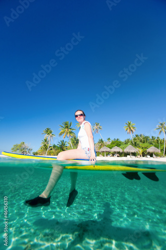 Photo: Woman sitting on a surfboard at ocean Woman sitting on a surfboard at ocean