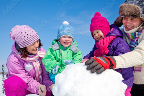 Photo: Happy family making snowman Happy family making snowman