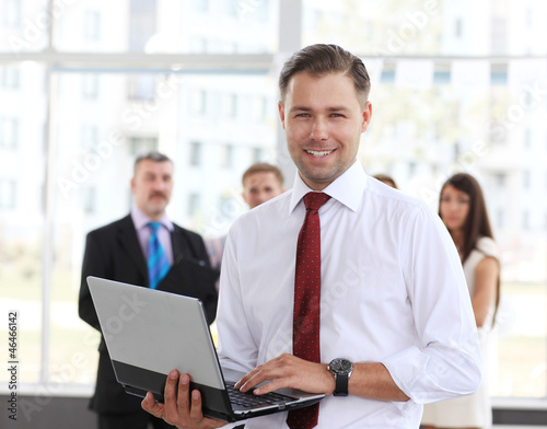 Photo: Smart business man using laptop with colleagues Smart business man using laptop with colleagues