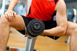 Man Using Dumbbell In Gymnasium