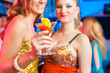 People in club or bar drinking cocktails