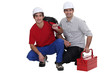 Two electricians crouching down