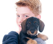 Teenager mit jungem Dackel auf dem Arm