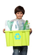 kid holding recycling tub full of empty plastic bottles