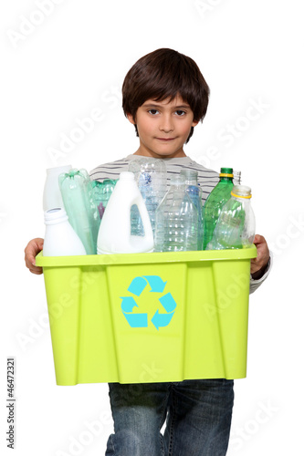 Photo: kid holding recycling tub full of empty plastic bottles kid holding recycling tub full of empty plastic bottles