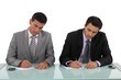 Businessmen filling in forms