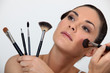 Woman holding various make-up brushes