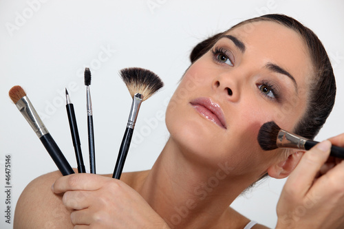 Photo: Woman holding various make-up brushes Woman holding various make-up brushes