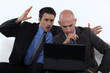 Two stressed office worker with laptop