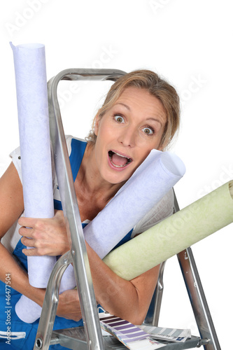 Photo: Happy woman with rolls of wallpaper Happy woman with rolls of wallpaper