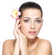 Beauty face of young woman with flower. Beauty treatment concept