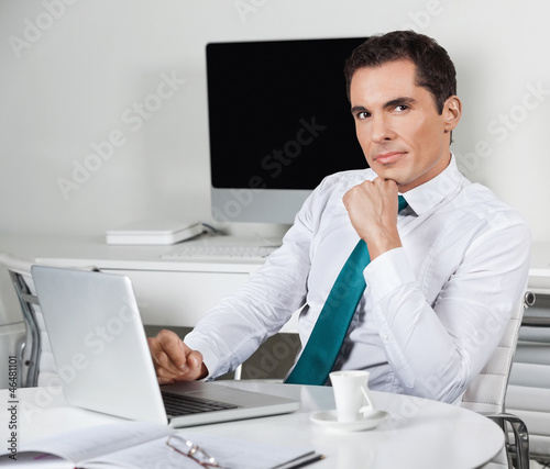 Photo: Manager arbeitet am Laptop im Büro Manager arbeitet am Laptop im Büro