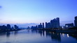 Time lapse of cityscape by the river at dusk.
