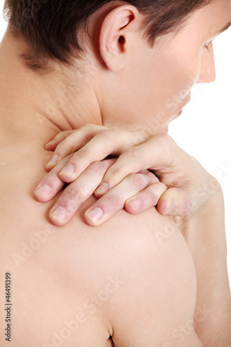 Photo: Young man with hands on his back Young man with hands on his back