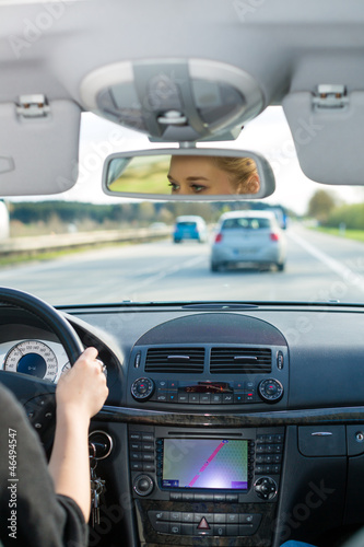 Photo: Young woman driving by car on motorway Young woman driving by car on motorway