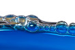 Blue bubbles in clear water against white