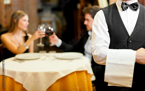 Photo: Couple at restaurant: focus on waiter Couple at restaurant: focus on waiter