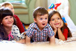 group of happy kids watching tv at home