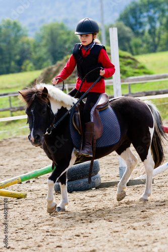 Photo: Horse riding - lovely girl is riding a pony Horse riding - lovely girl is riding a pony