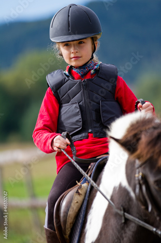 Photo: Horse riding - lovely girl is riding a pony Horse riding - lovely girl is riding a pony