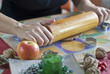 Hand rolling out dough with rolling pin