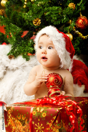 Photo: Christmas baby holding red gift Christmas baby holding red gift