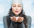 Foto: Christmas Girl. Winter woman Blowing Snow Christmas Girl. Winter woman Blowing Snow