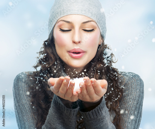 Photo: Christmas Girl. Winter woman Blowing Snow Christmas Girl. Winter woman Blowing Snow