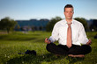 Photo: Barefoot businessman meditating in a beautiful park Barefoot businessman meditating in a beautiful park