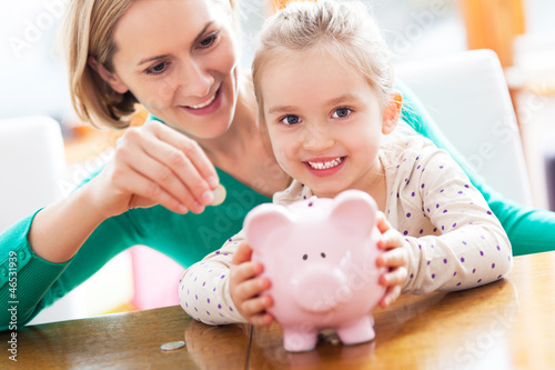 Photo: Mother and daughter with piggy bank Mother and daughter with piggy bank