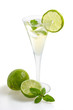 Aperitif mit Limetten und Minze in einer Sektflöte